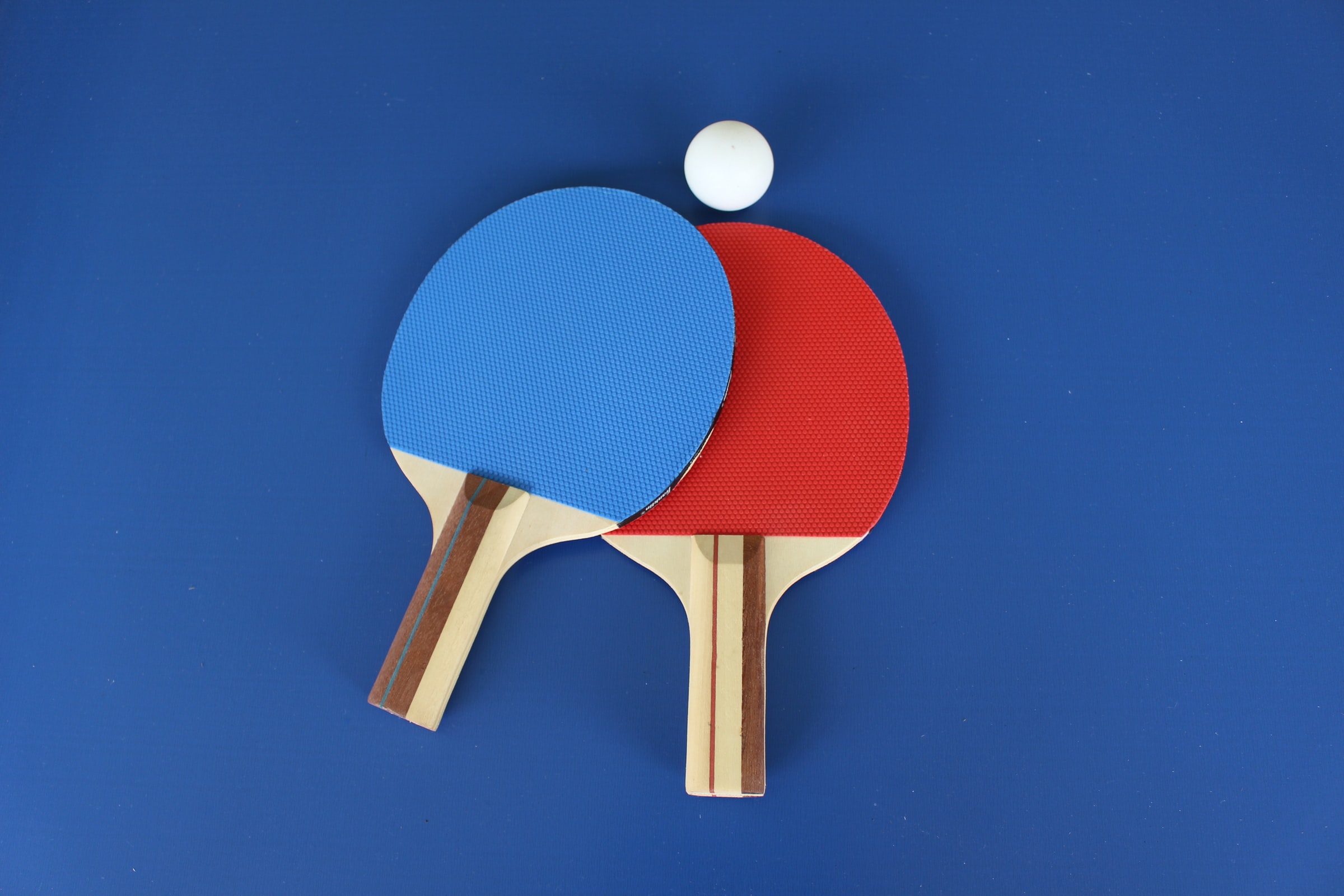 Ping pong paddles and a ball over a table